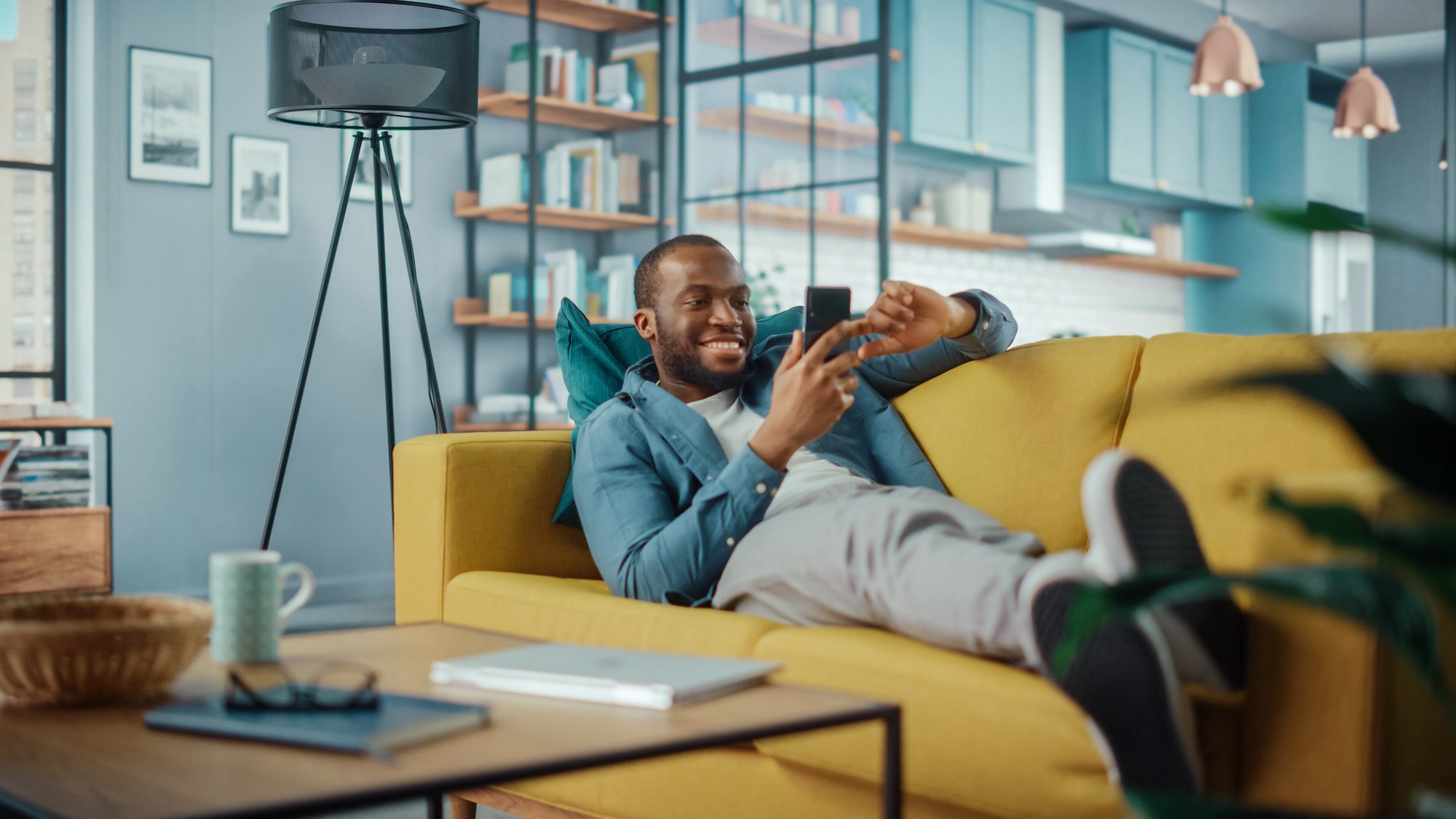 guy-on-phone-laying-on-yellow-couch-web