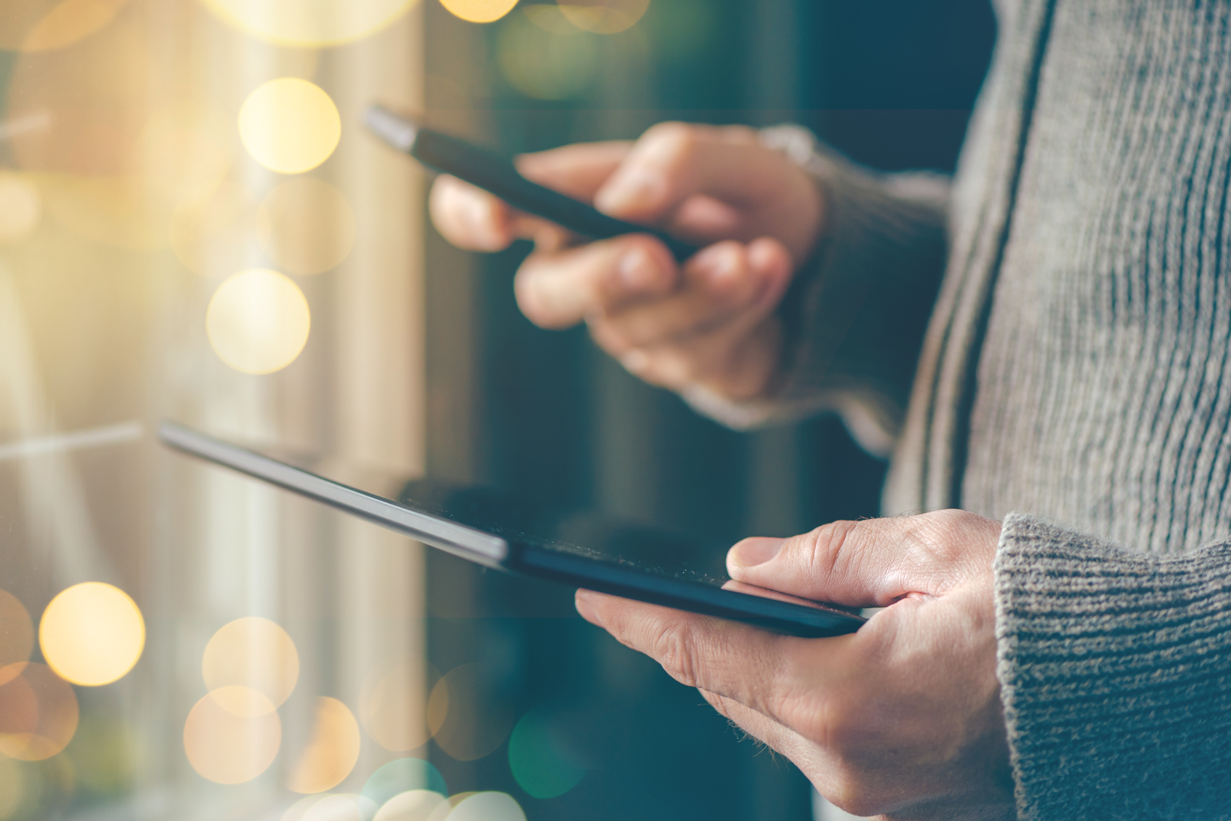 man-holding-phone-tablet-bokeh-lights.jpeg