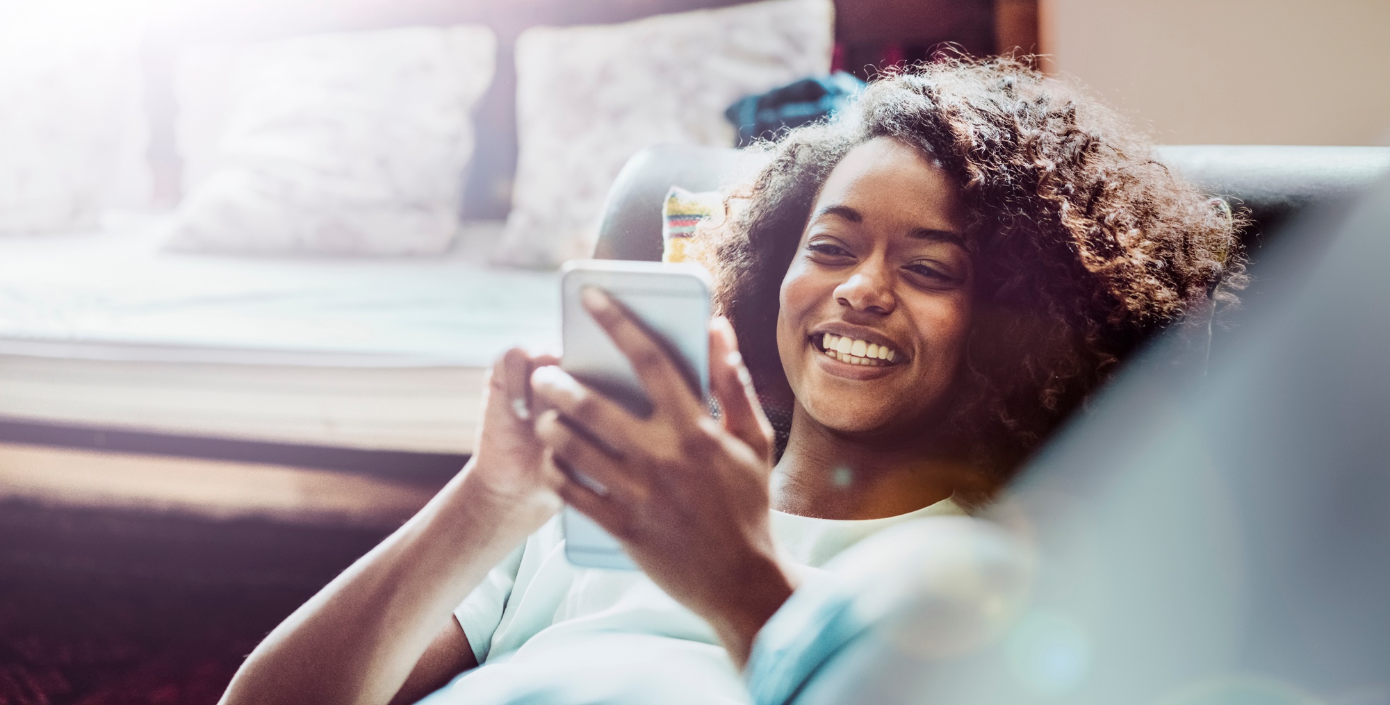 woman-laying-on-couch-smartphone-smiling.jpg