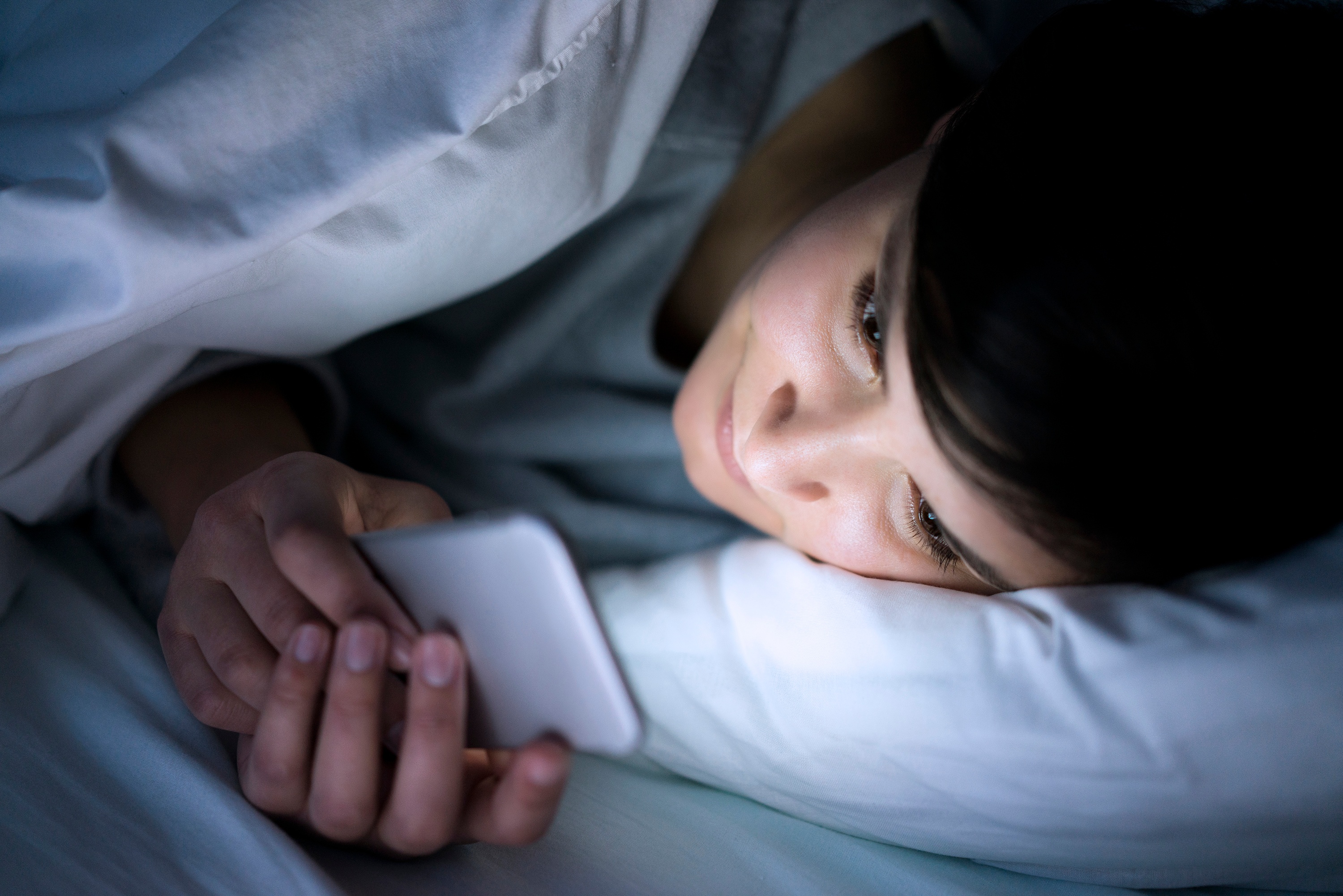 woman-watching-smartphone-in-bed-med